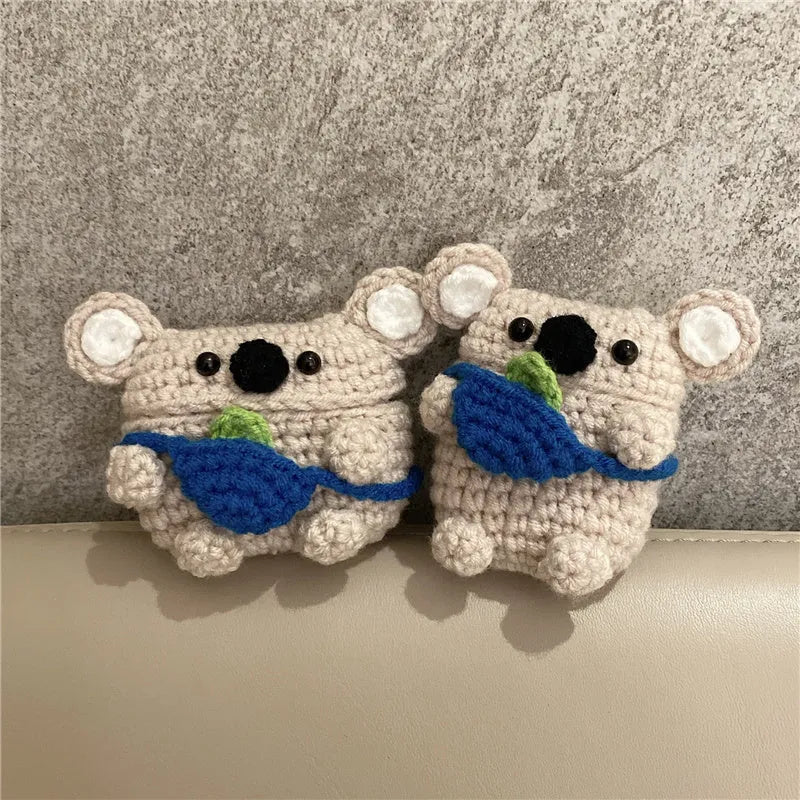 Handmade knitted AirPods case shaped like a backpack with koala ears on a blue background.