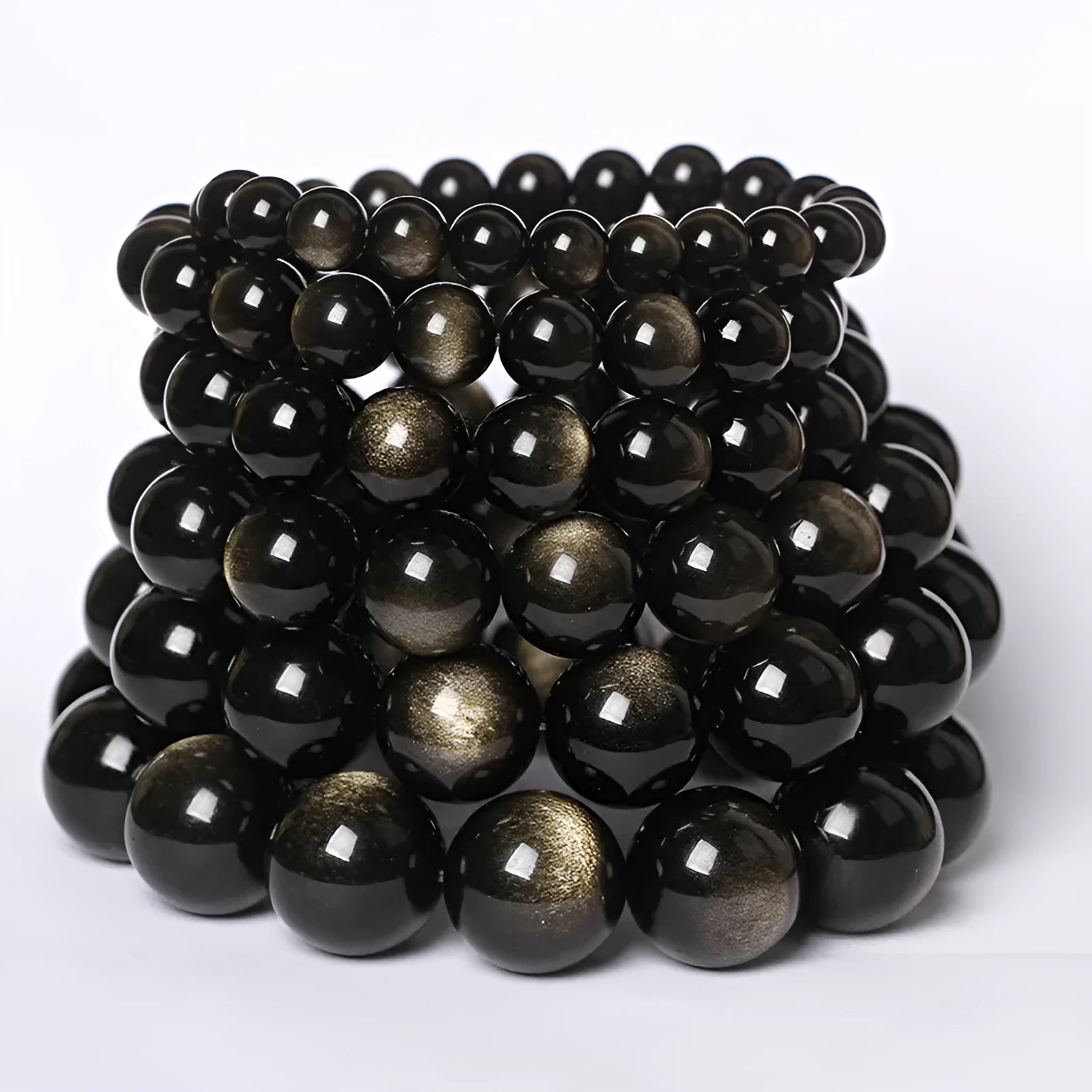 Hand-woven round obsidian crystal bracelet in black, silver, and rainbow eye colours on a neutral background.