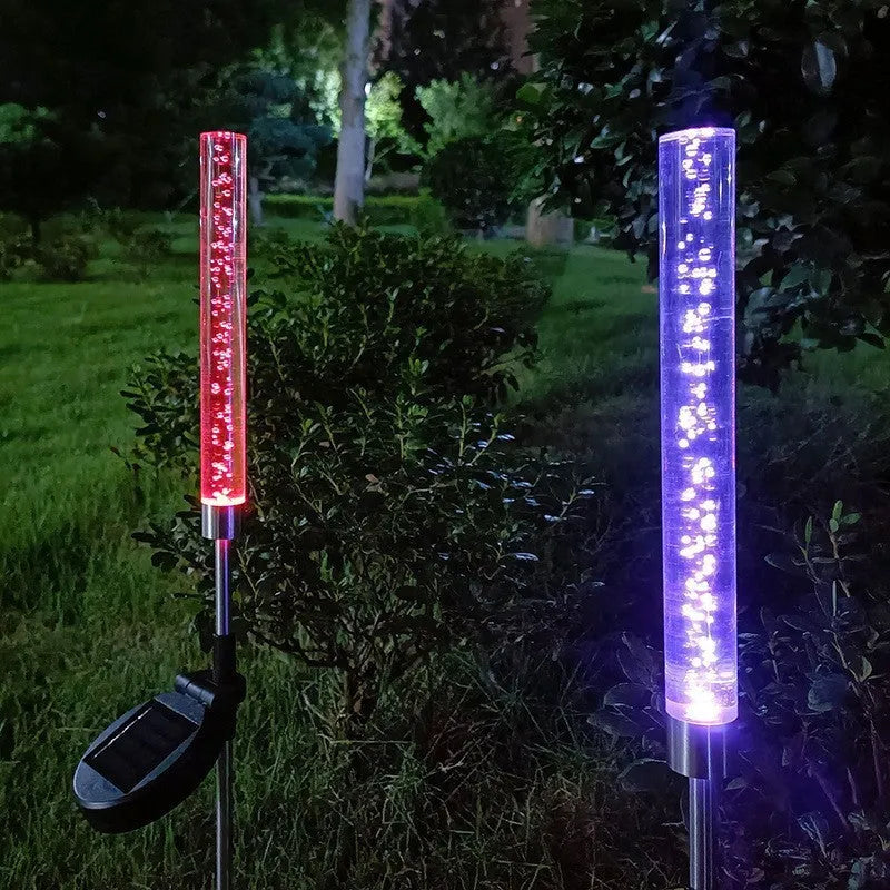 Solar bubble stick lawn lamp with colourful slow-flash crystal effect and warm light on a garden lawn