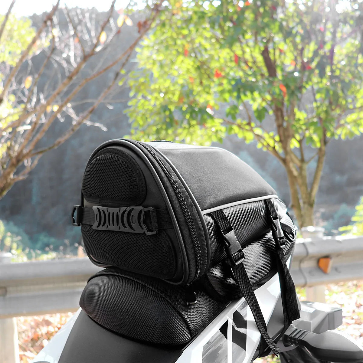 Black motorcycle seat bag with reflective strips, shown with carrying strap.