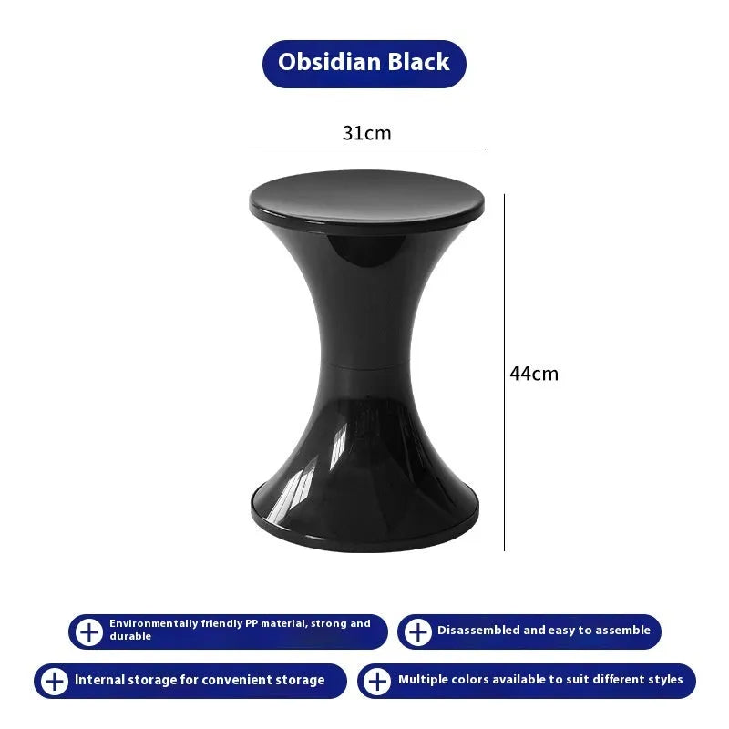 Green plastic hourglass-shaped shoe changing stool on a wooden floor.