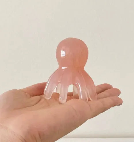 Pink octopus-shaped facial massage comb for periocular meridian stimulation with storage bag