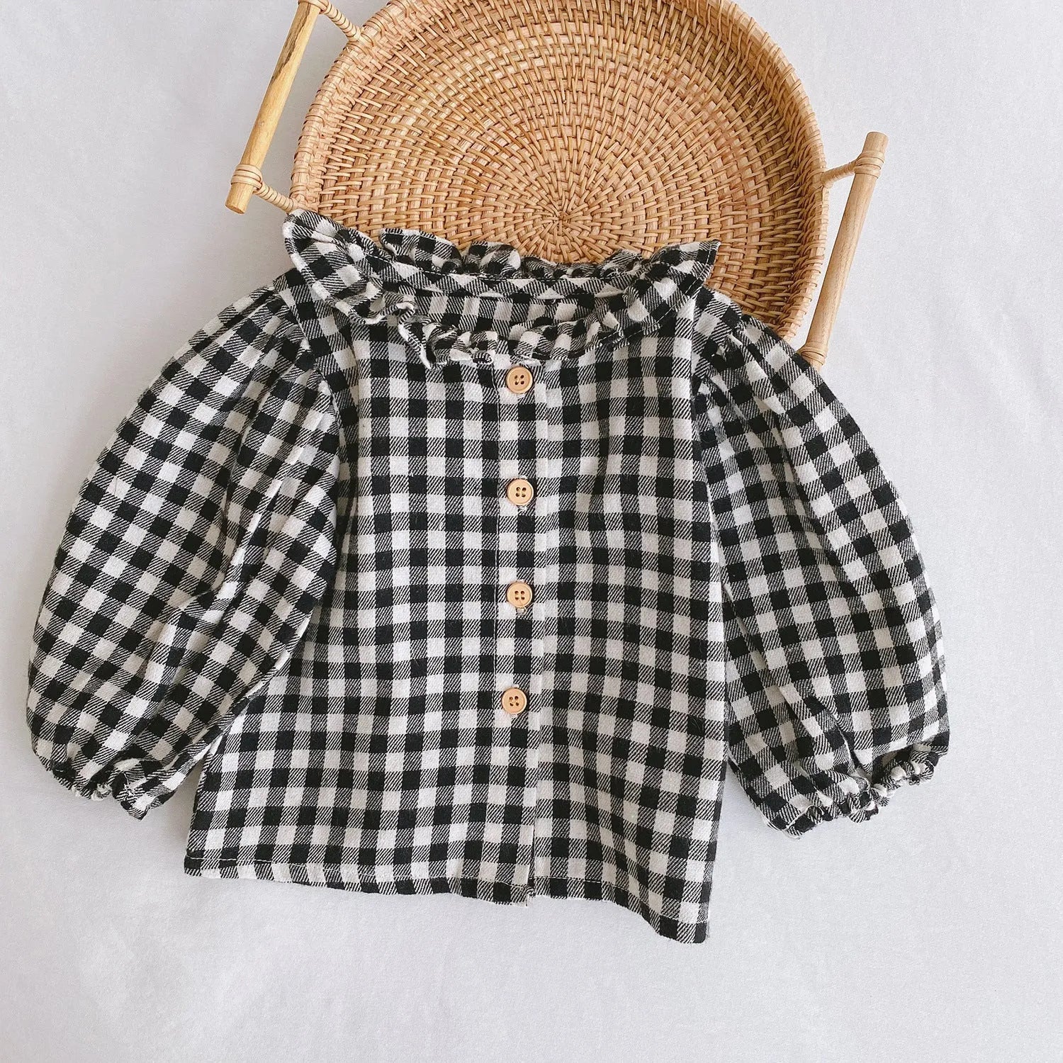 Baby girl wearing a pleated lotus leaf design cotton romper in a triangle climb style.