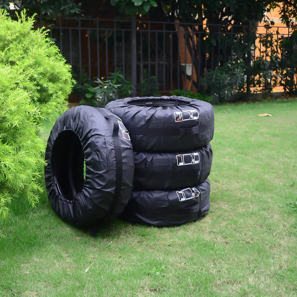 Four black Oxford cloth polyester tyre protective covers laid flat, showing their circular shape.