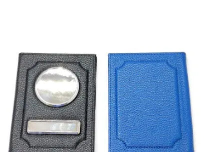 Black synthetic leather passport case with expandable design and aluminum lenses on a plain background