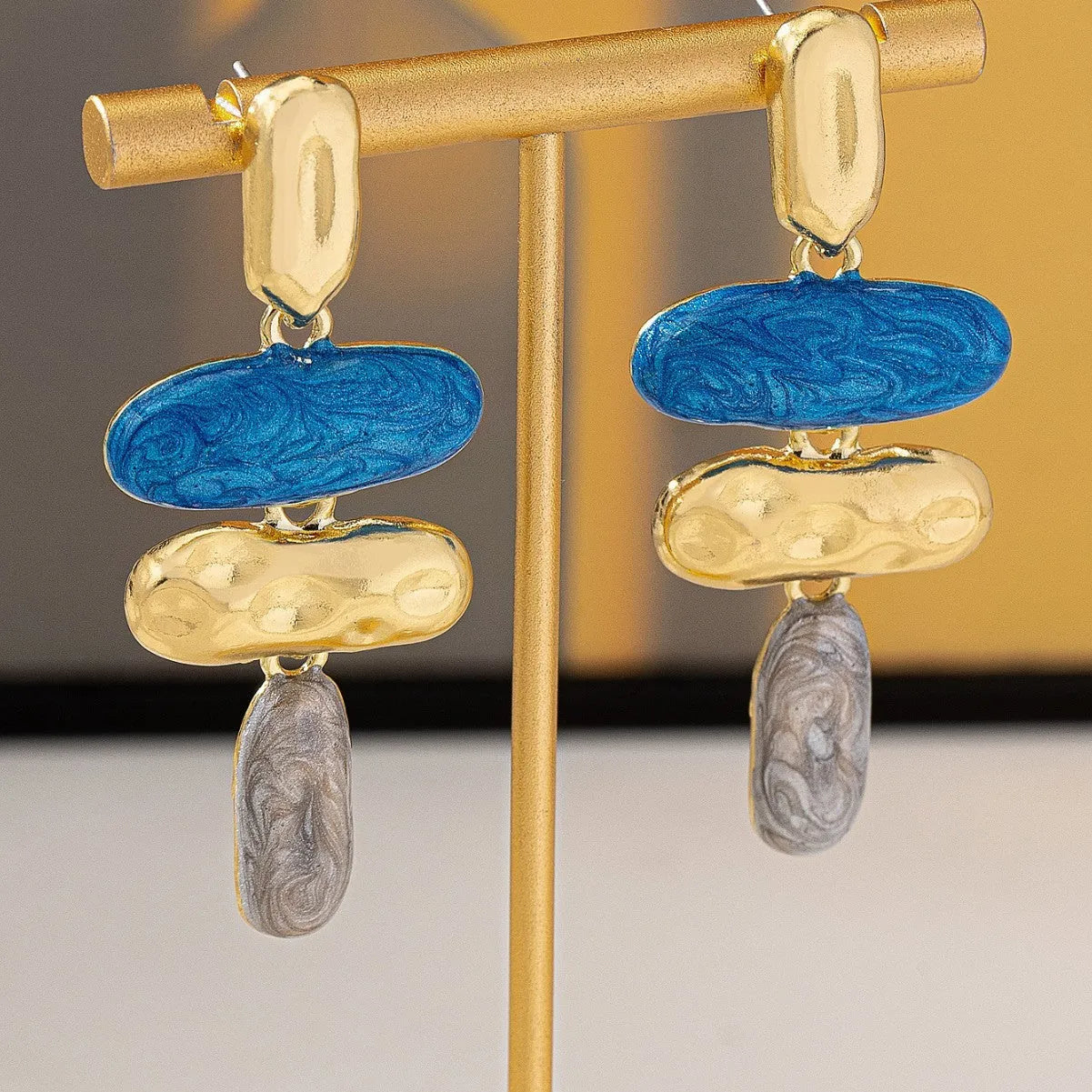 A pair of women's geometric stud earrings with a multicolour electroplated finish on a zinc alloy base.