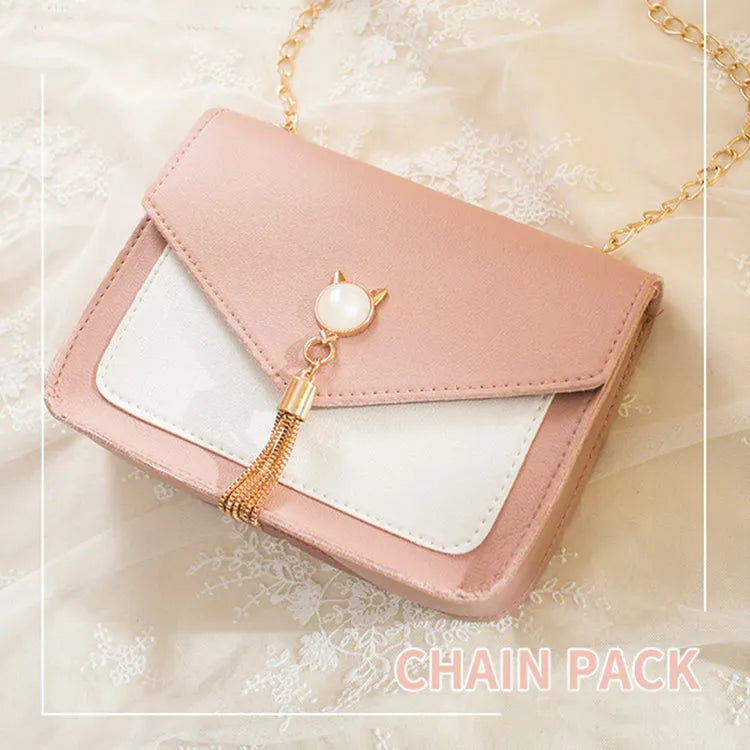Small square PU leather messenger bag with cat tassel decoration and chain strap on a white background