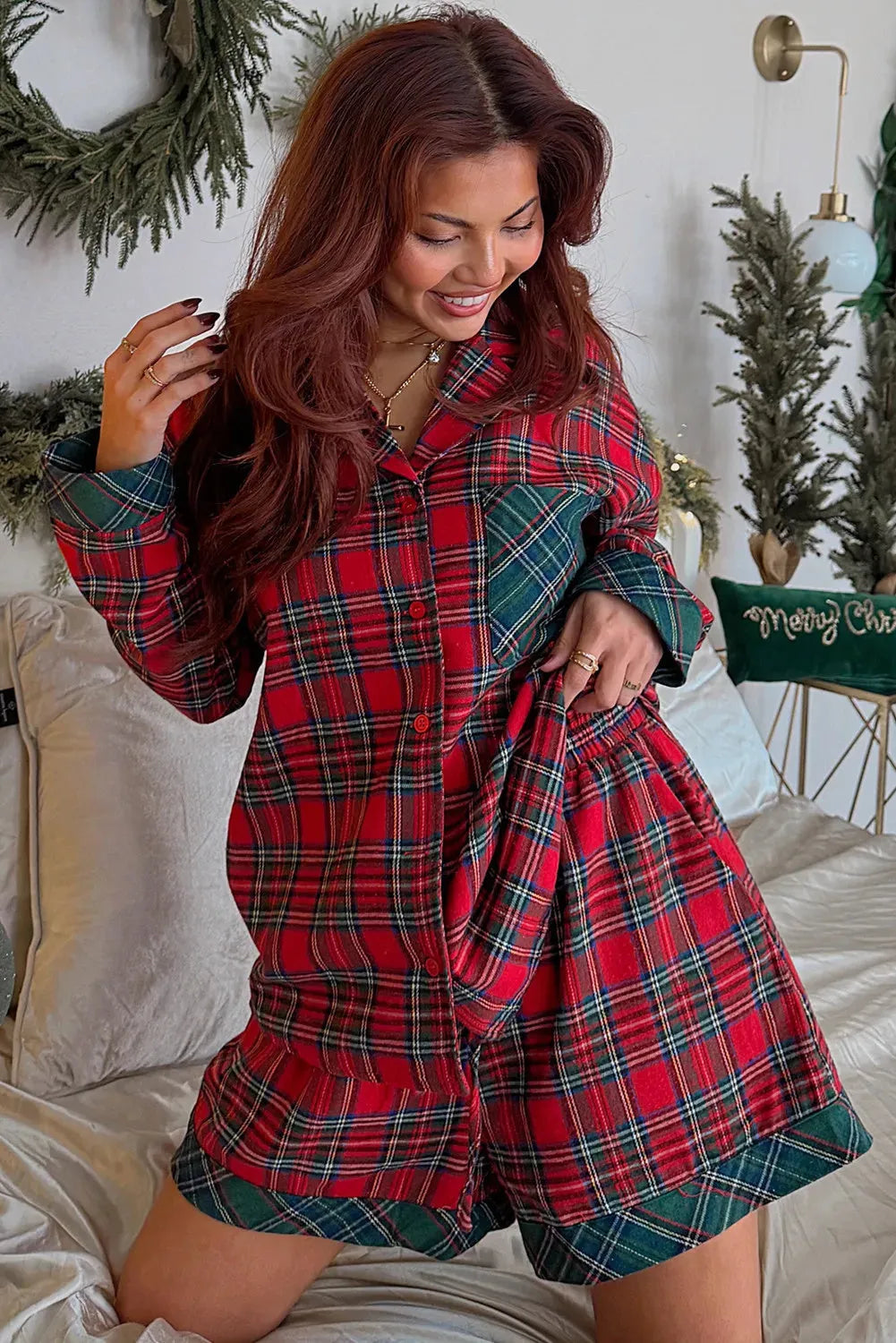 Red plaid Christmas pyjama set with long sleeve shirt and shorts on a hanger.