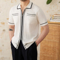 Black slim-fit men's polo shirt with a lapel collar and short sleeves on a hanger.