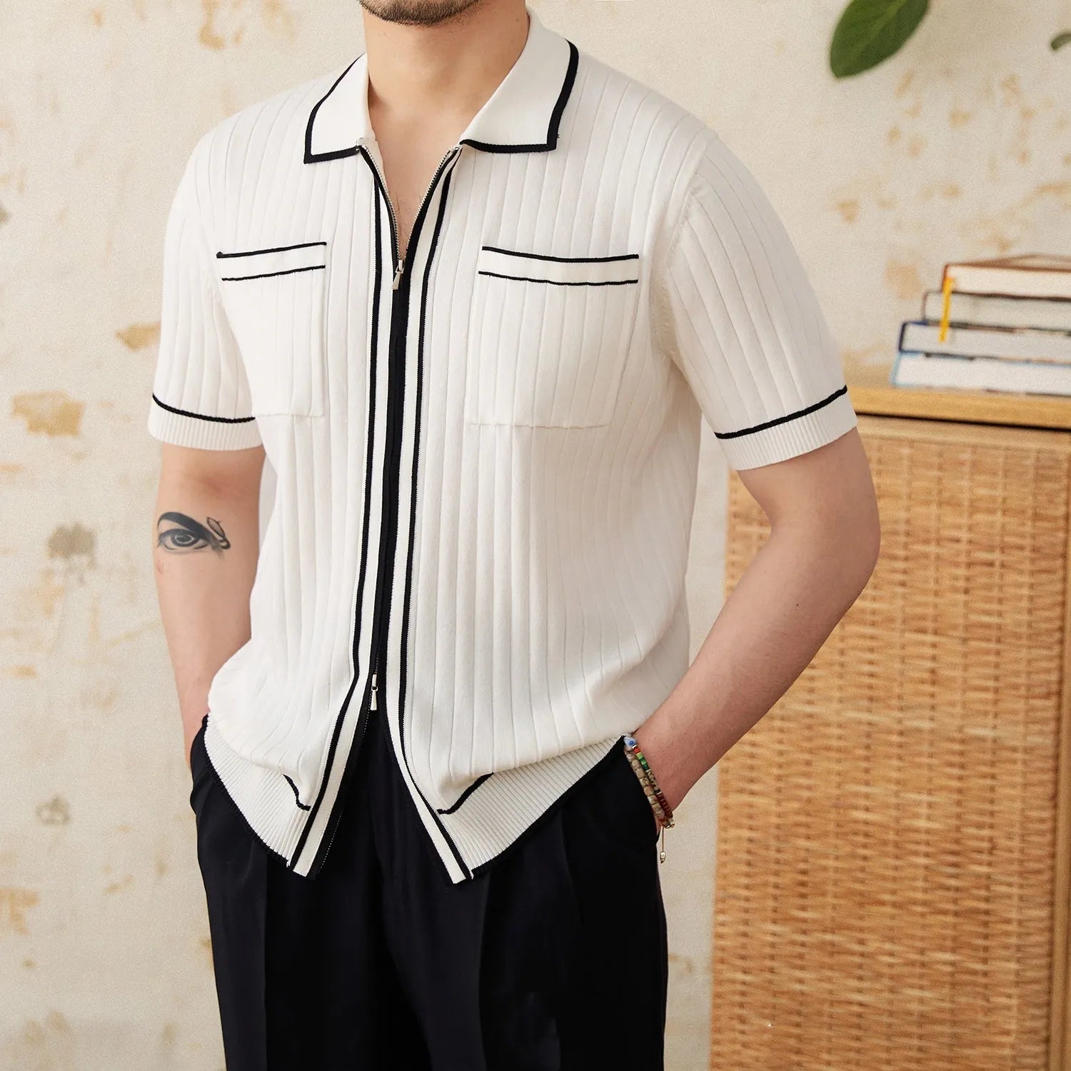 Black slim-fit men's polo shirt with a lapel collar and short sleeves on a hanger.
