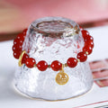 Natural red agate bracelet with woven bead design on a wrist.