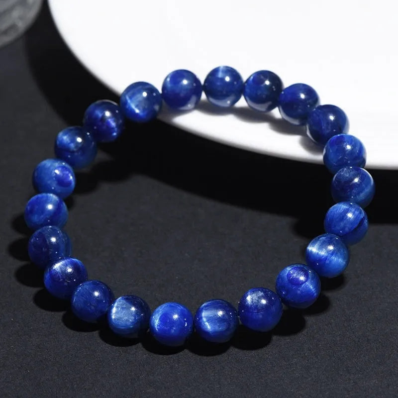 Blue crystal ball bracelet with geometric beads and a Ruyi charm on a white background.