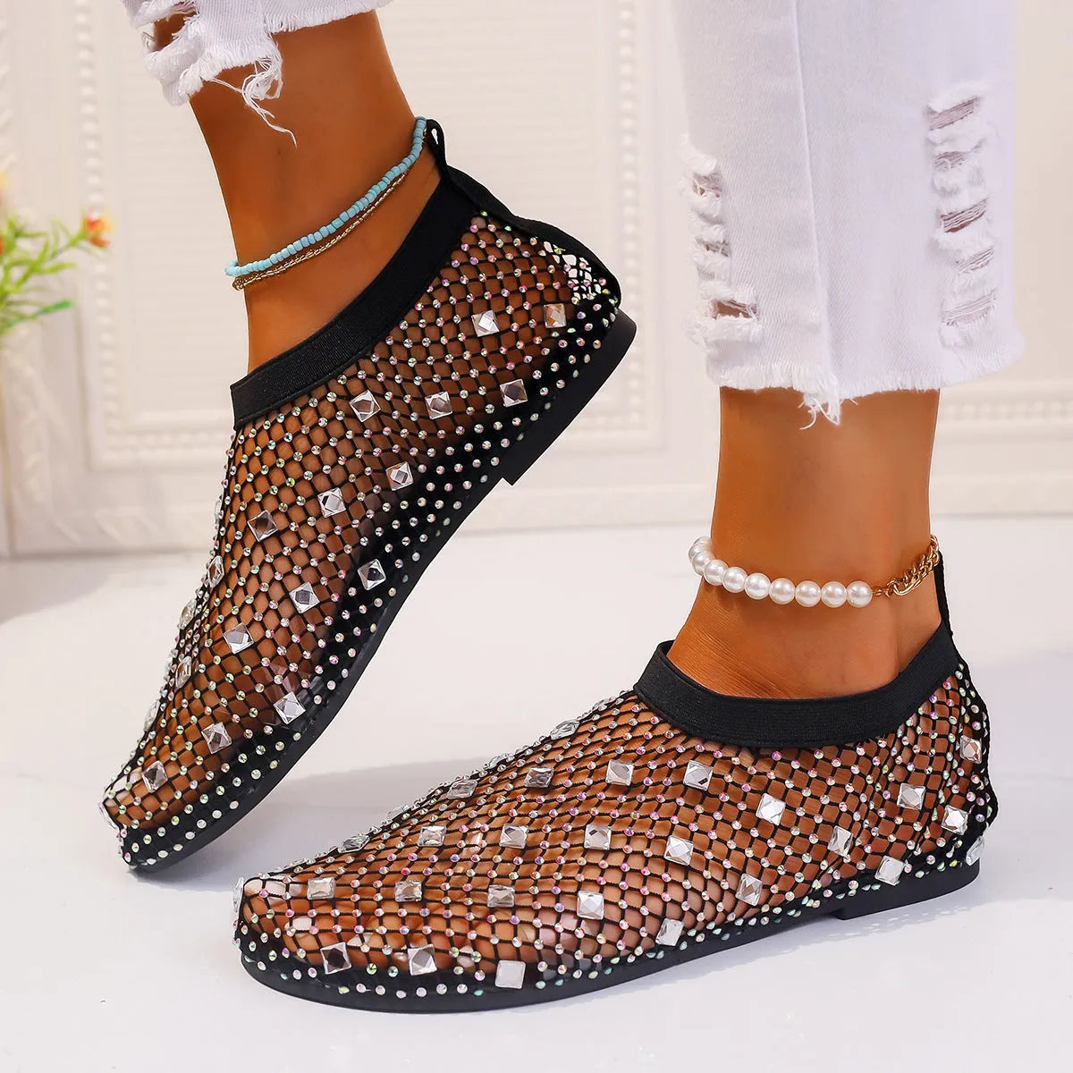 Women's white and colourful mesh flat sandals with rhinestone decoration and a round toe.