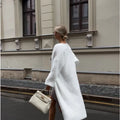 White longline knitted cardigan jacket for women, shown loose-fit with long sleeves.