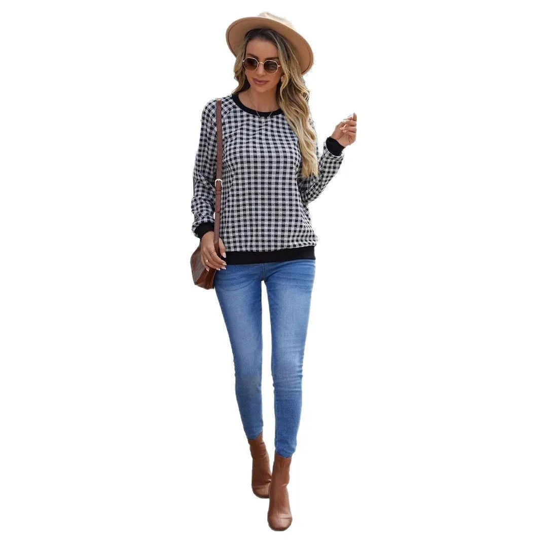 Black and white plaid print long sleeve pullover sweater for men on a neutral background.