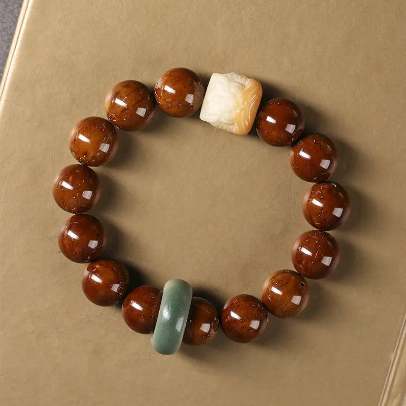Hand-woven bracelet with 13mm round beads and a carved lion bead centrepiece in ivory nut style.