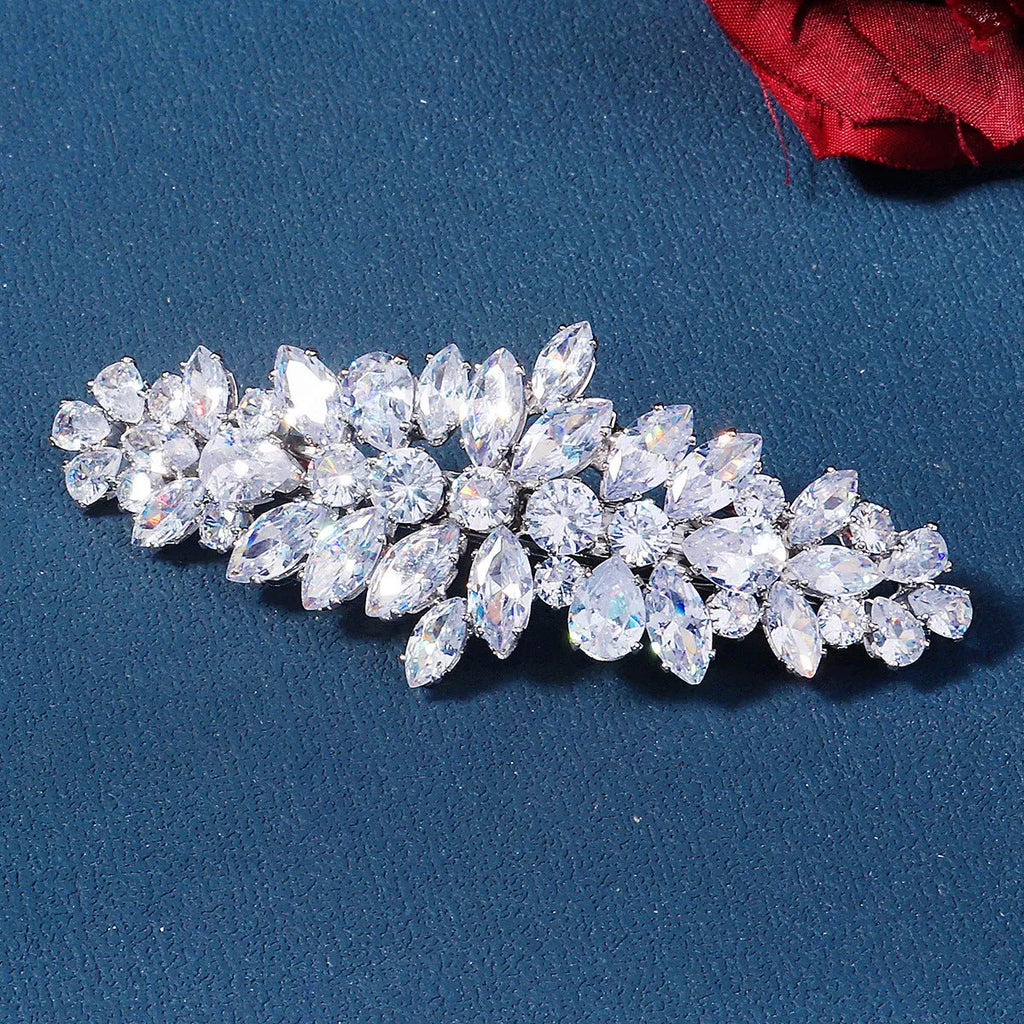 Women's inlaid zircon spring clip barrettes with electroplated leaf design on a neutral background