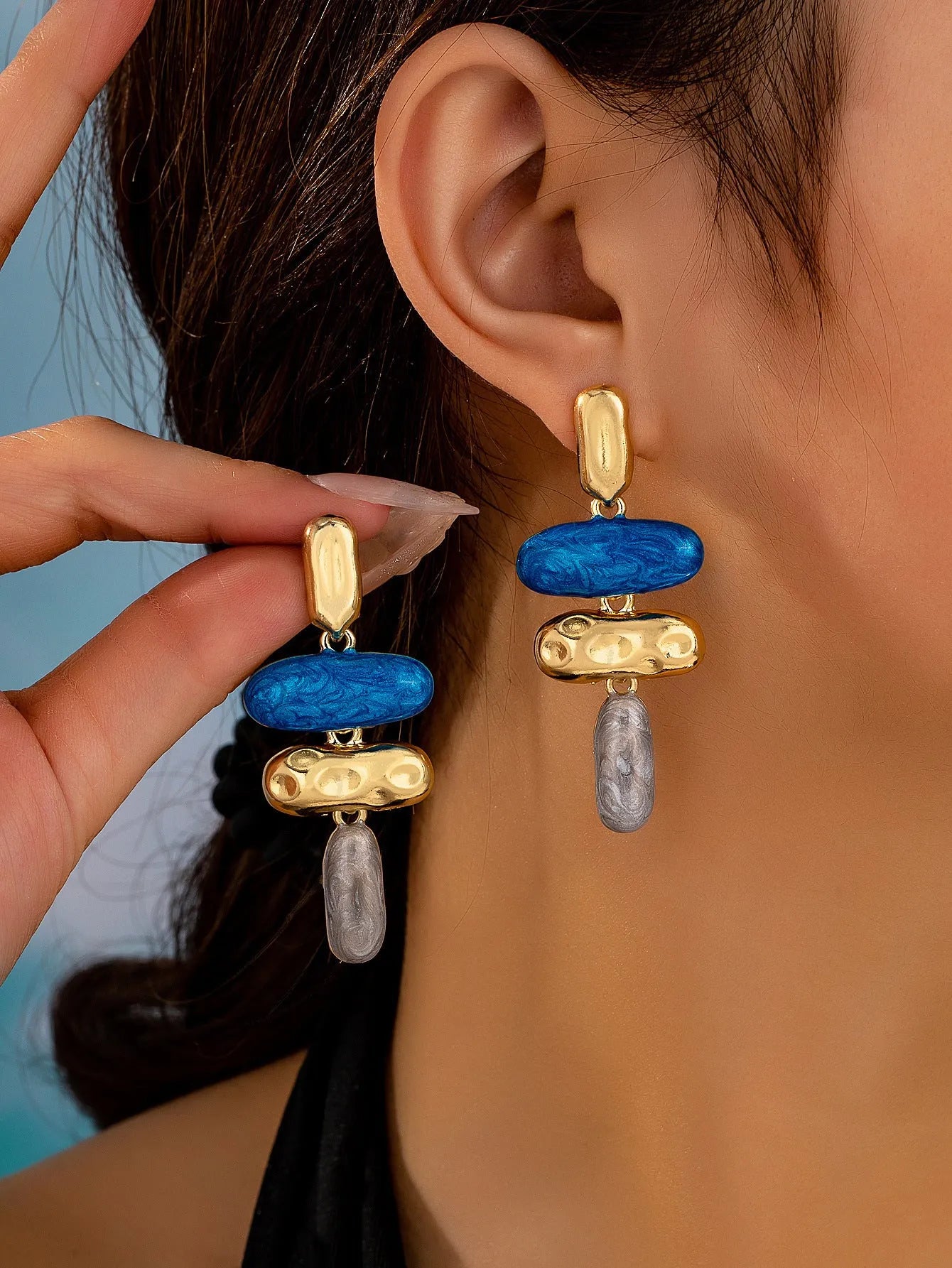 A pair of women's geometric stud earrings with a multicolour electroplated finish on a zinc alloy base.
