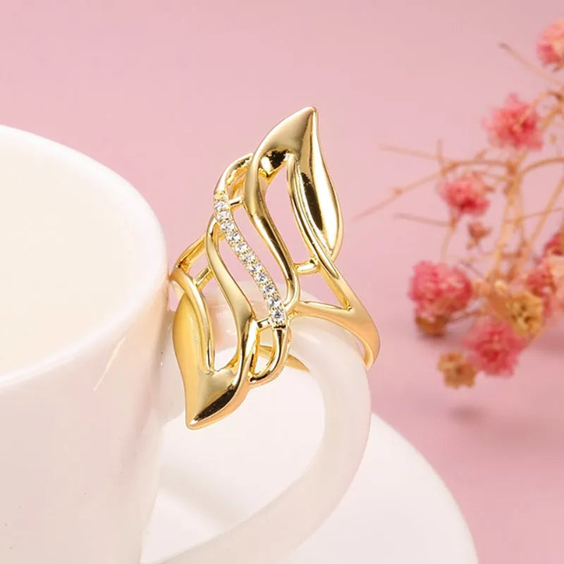 Women's exaggerated curve ring in Q611 gold colour with zircon treatment on copper