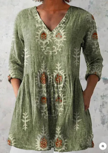 A woman wearing a printed, loose-fitting dress with a wide waist and three-quarter length sleeves.