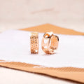 Circular rose gold earrings with a hollowed out design of three interlinked hearts.