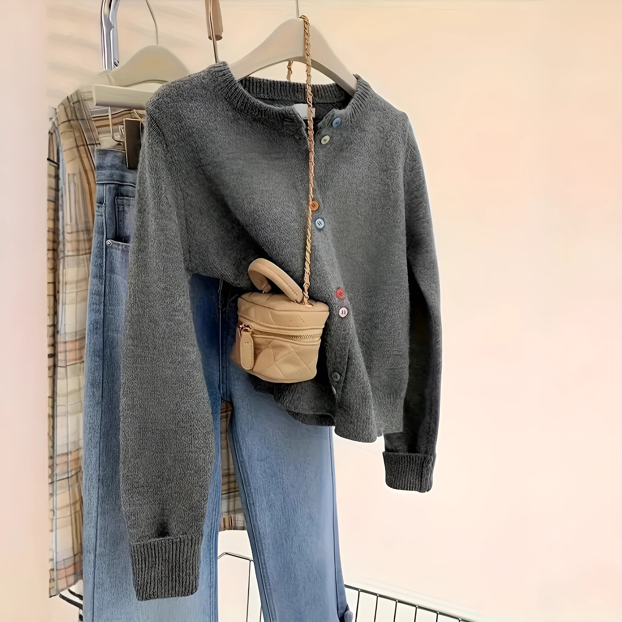 Women's dark grey button-front polyester cardigan sweater on a hanger.