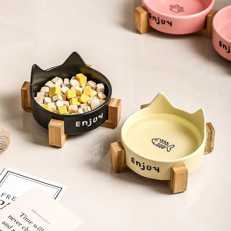 Porcelain cat bowl with cat ear and paw design on a wooden feeding frame, in pink colour.