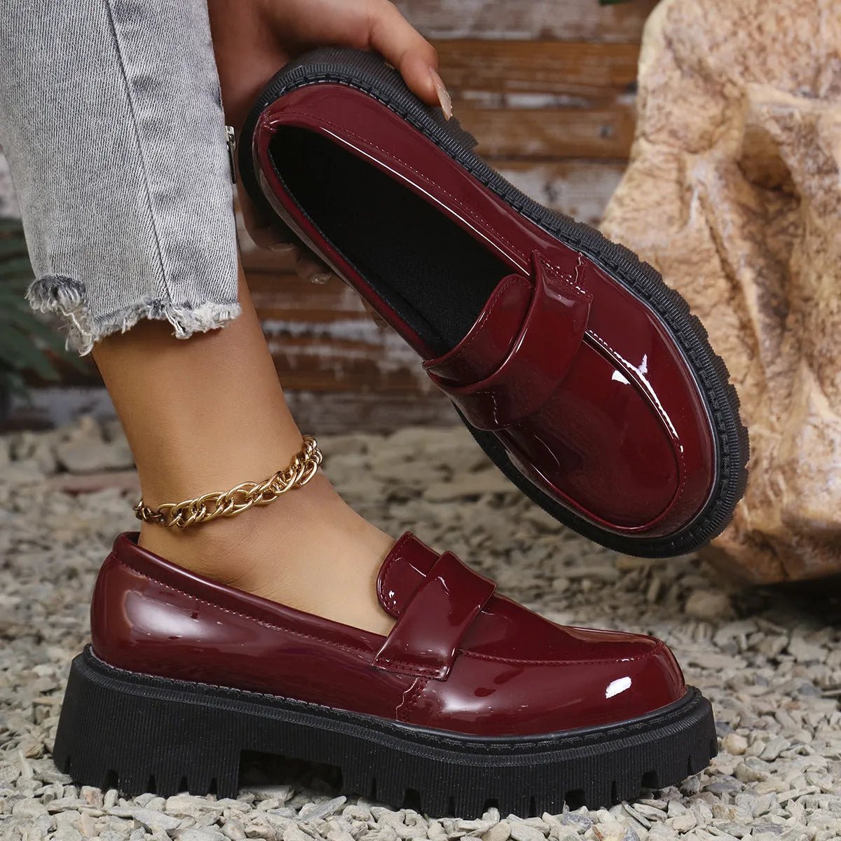 Women's black slip-on loafers with a chunky platform heel and rubber sole, shown from the side.