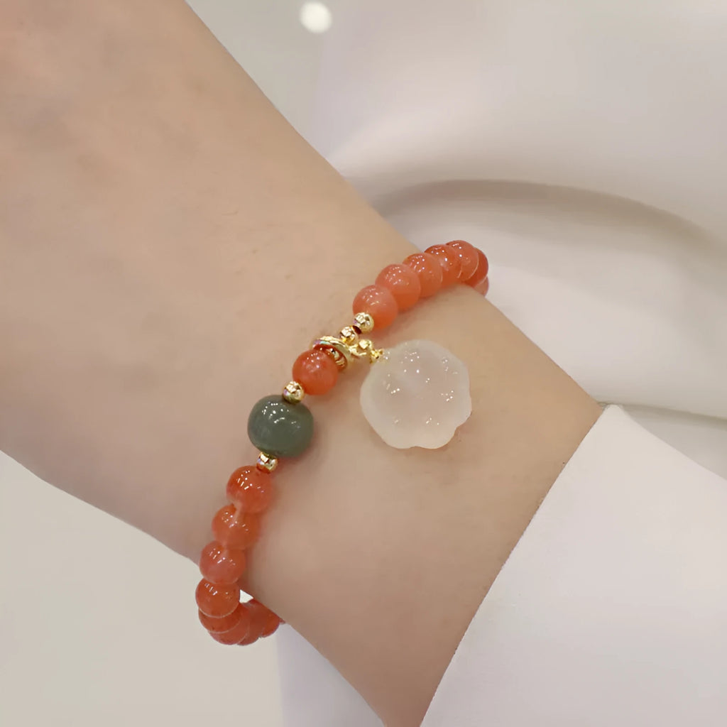 Polished agate bracelet with cat's paw charm and jade beads on adjustable cord.