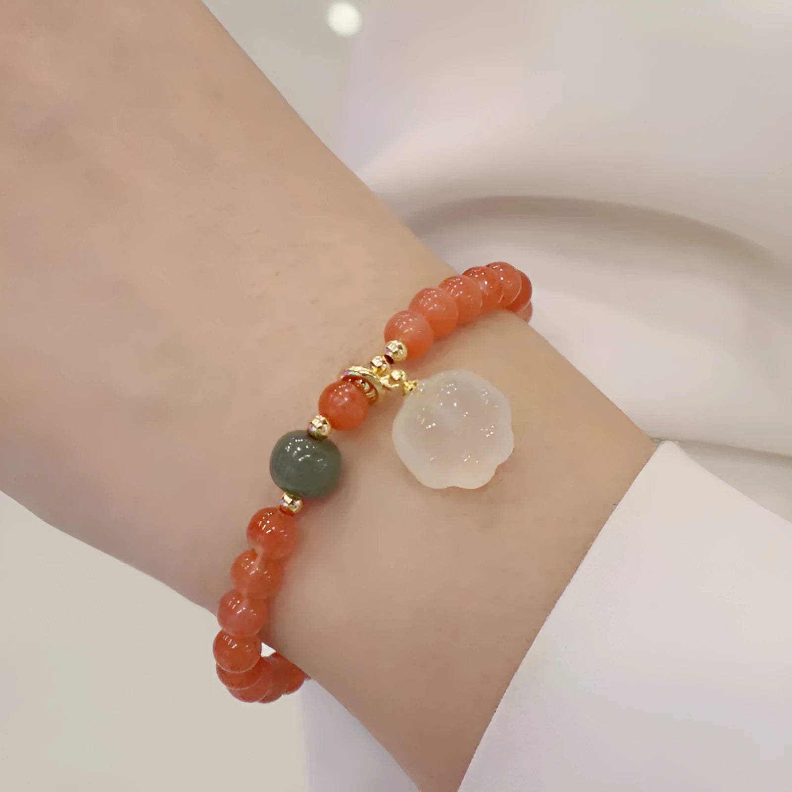 Polished agate bracelet with cat's paw charm and jade beads on adjustable cord.