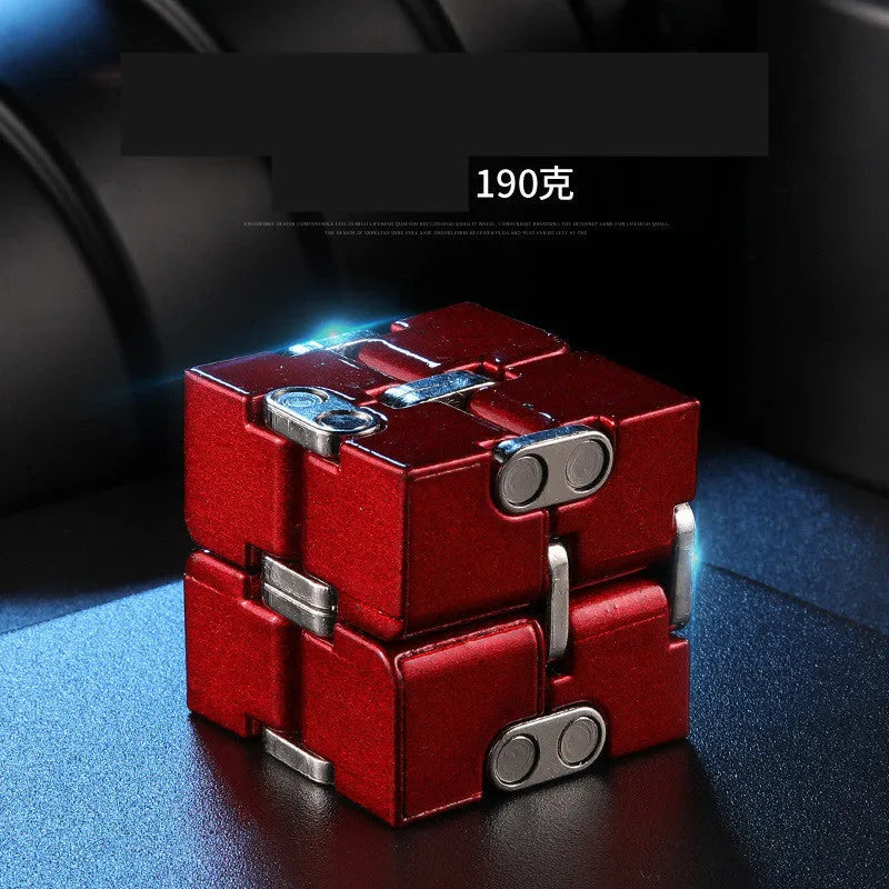 Zinc alloy infinity cube fidget toy showing black and silver rotating cube puzzle on a desk.
