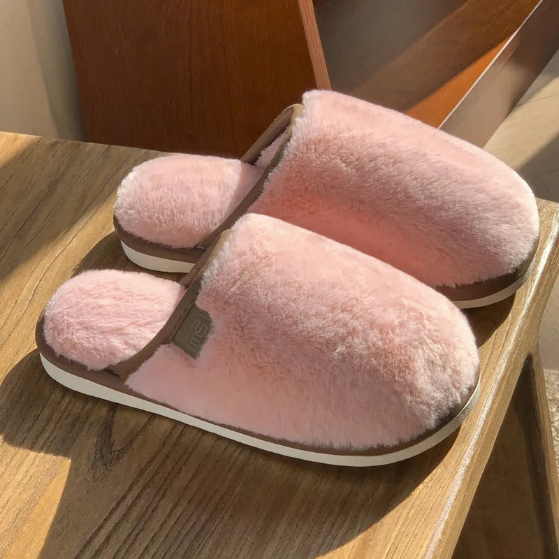 Pair of solid-colour plush house slippers with car stitching detail on the PVC upper.