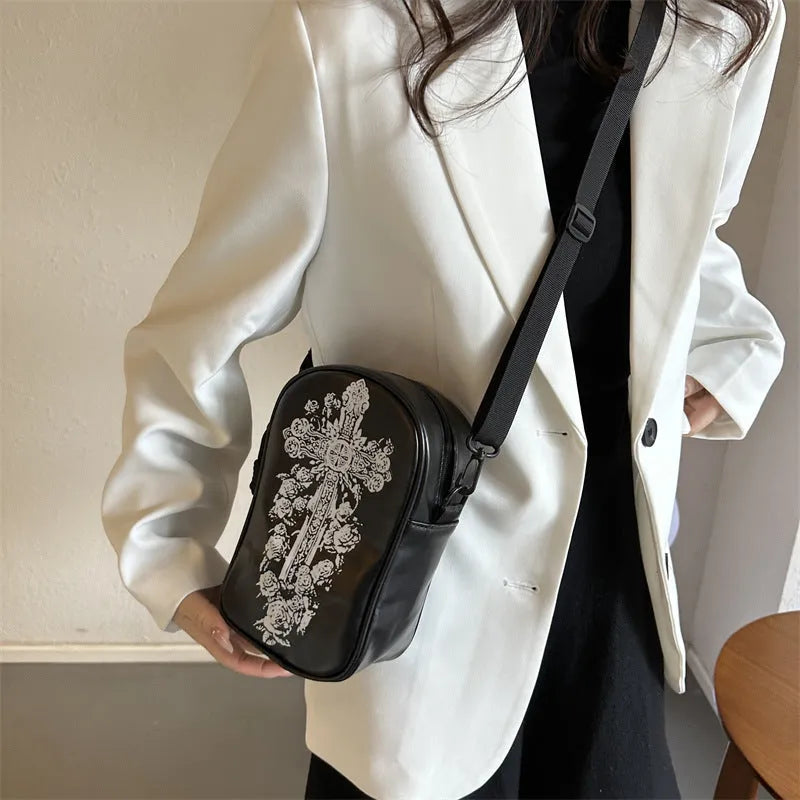 Black Halloween crossbody bag with orange pumpkin, white ghost, and bat graffiti print, shown on a model.