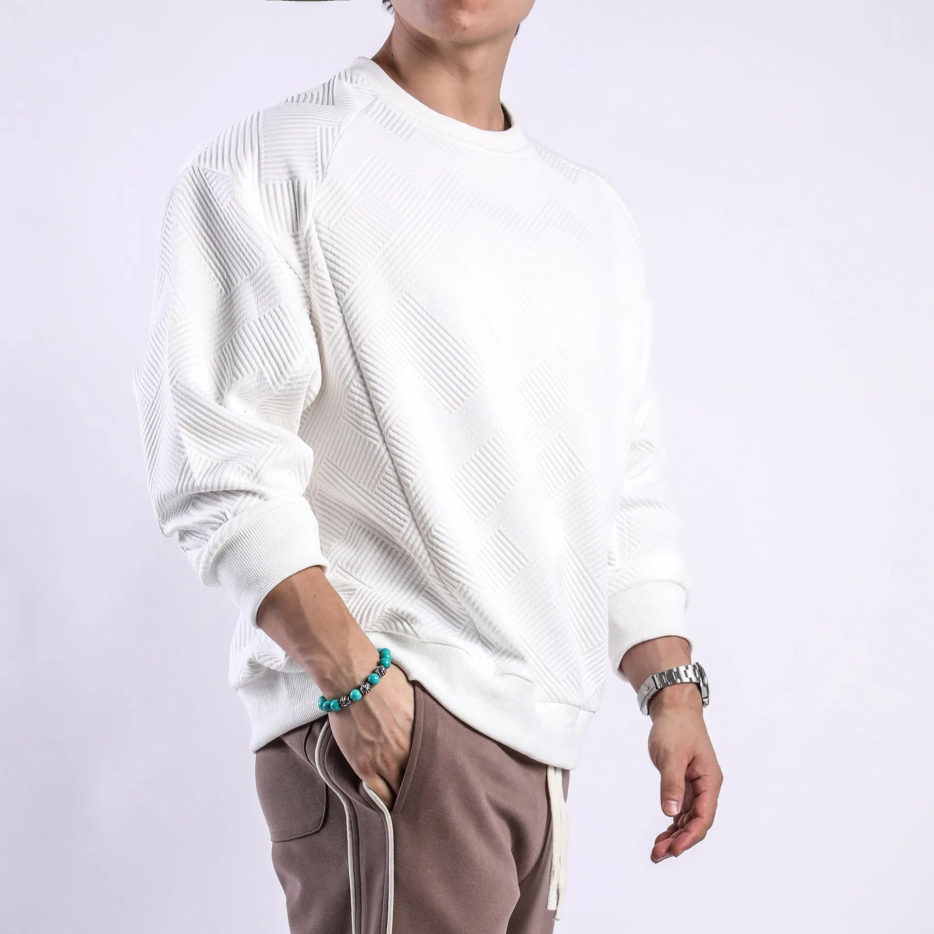 Man wearing a loose-fitting army green twill jacquard long-sleeved pullover sweater.