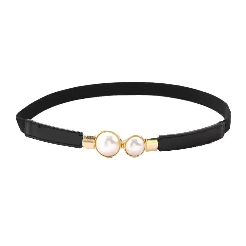 Thin black decorative jeans belt for women with an alloy buckle on a jeans waistband.