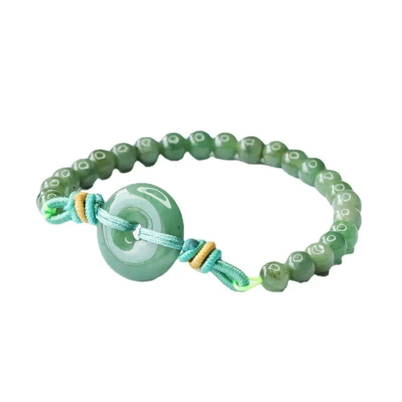 Emerald green jade bracelet with safety buckle closure and star charm on wrist