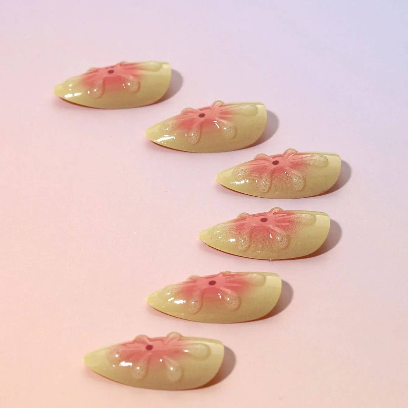 Set of plastic false nails with raised 3D cartoon flowers, jelly glue pot, and a nail file.
