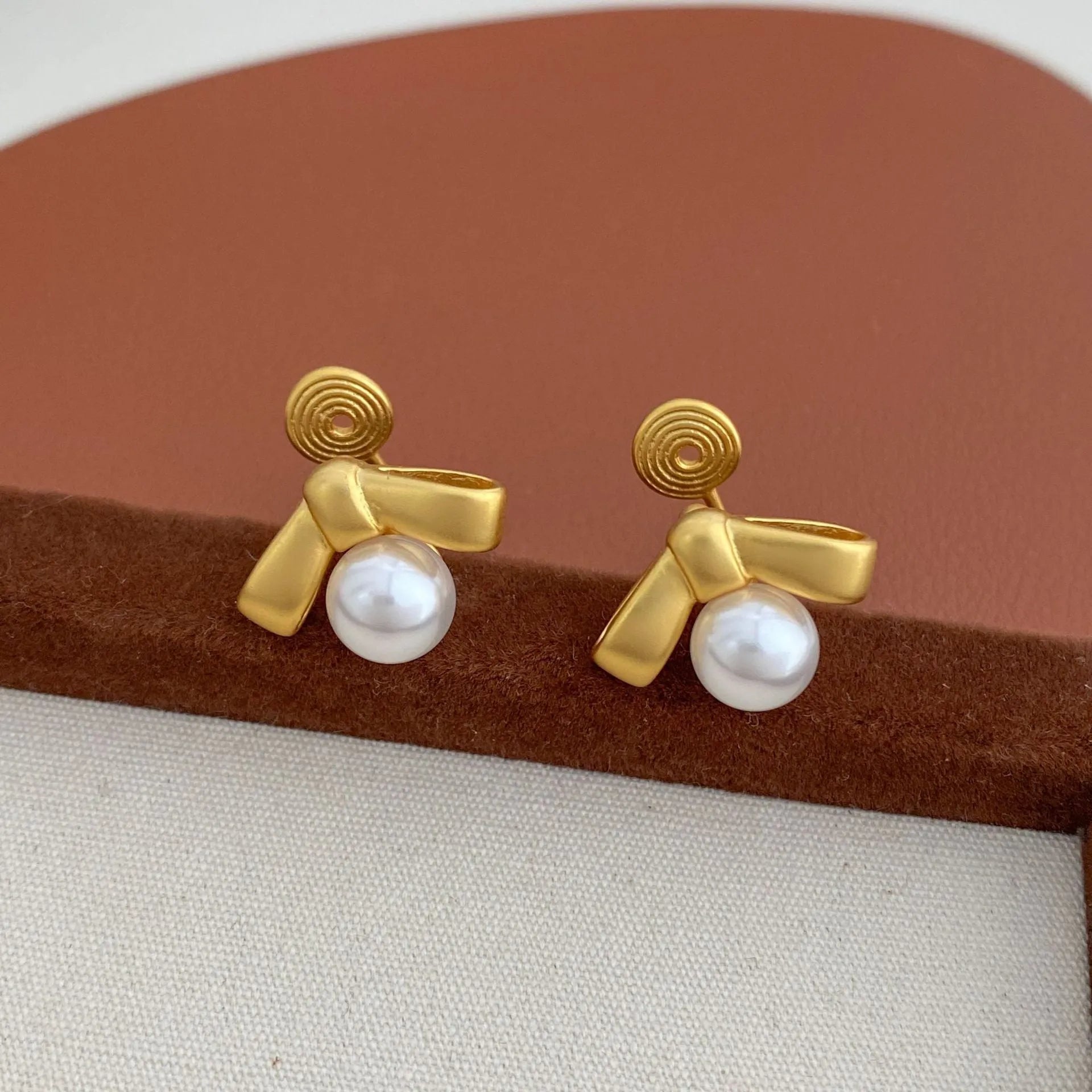 Matte bow earrings for women in matte gold clip-on style on a white background
