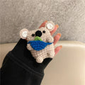 Handmade knitted AirPods case shaped like a backpack with koala ears on a blue background.