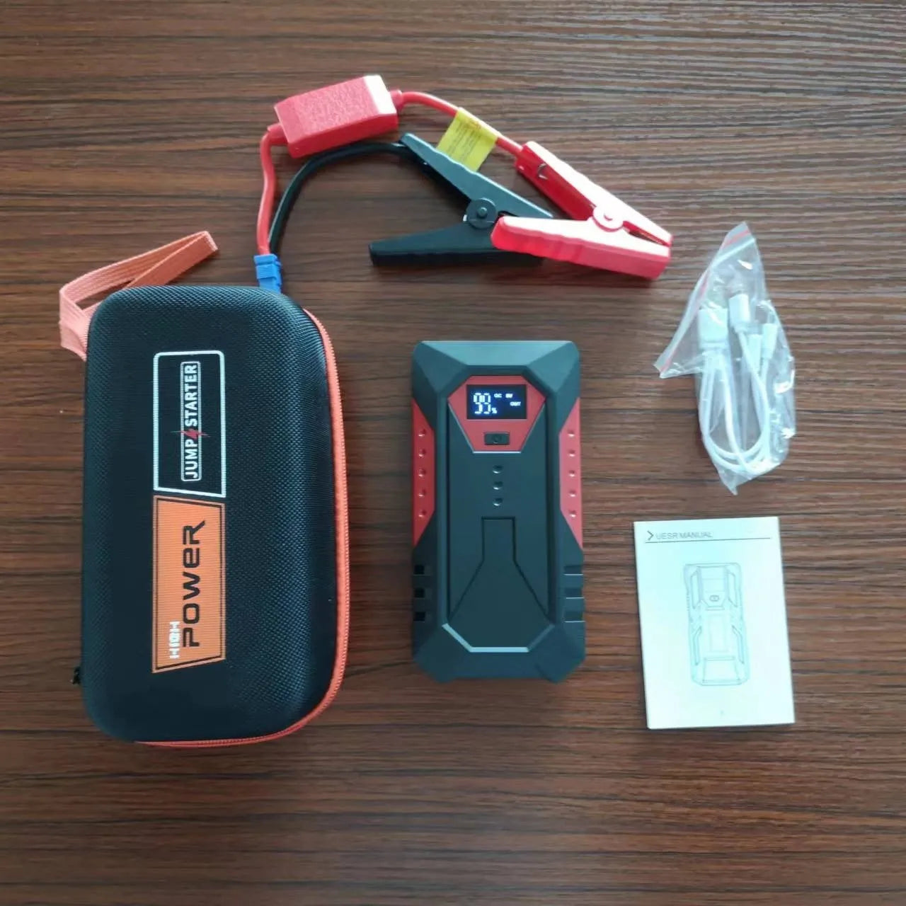 Red 12V car jump starter power bank with battery clamps and 18800mAh capacity