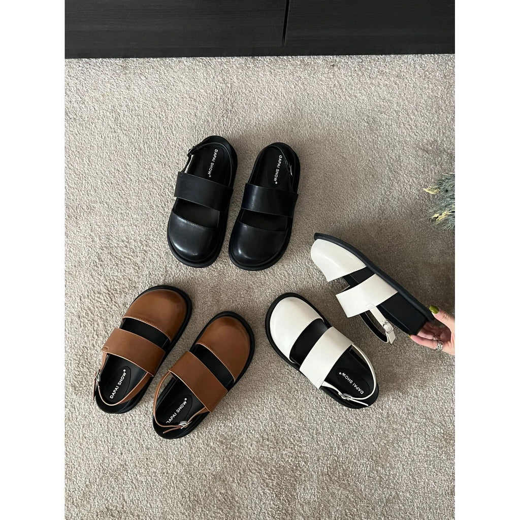 Korean style women's retro sandals with a black microfiber upper and adjustable ankle buckle on a PVC sole.