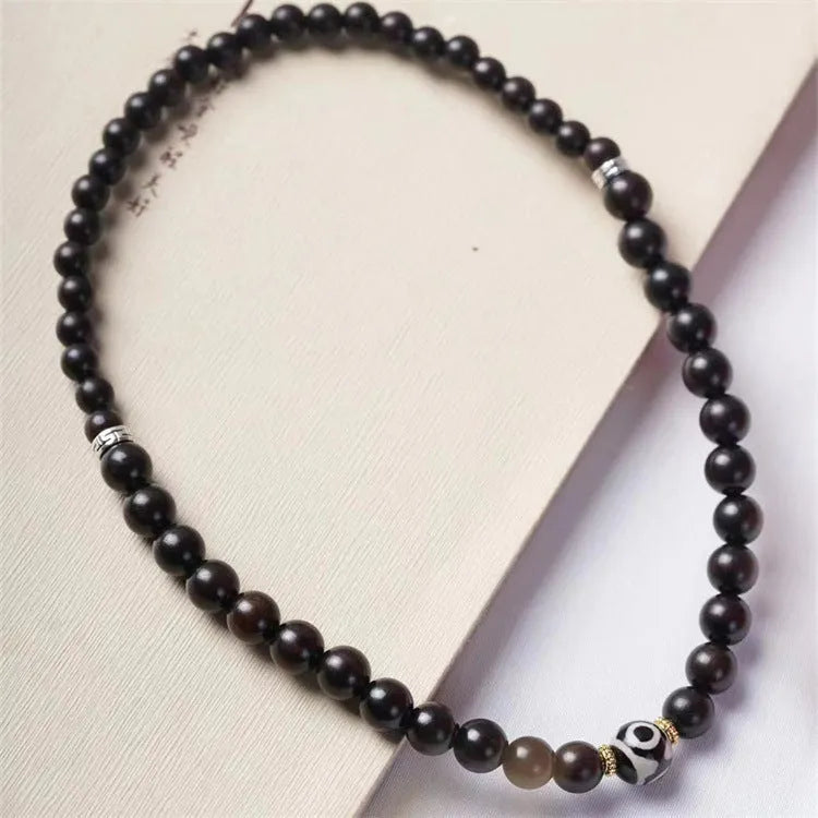 Dark ebony wood bracelet with 8mm Tibetan style beads showing two-circle pattern design