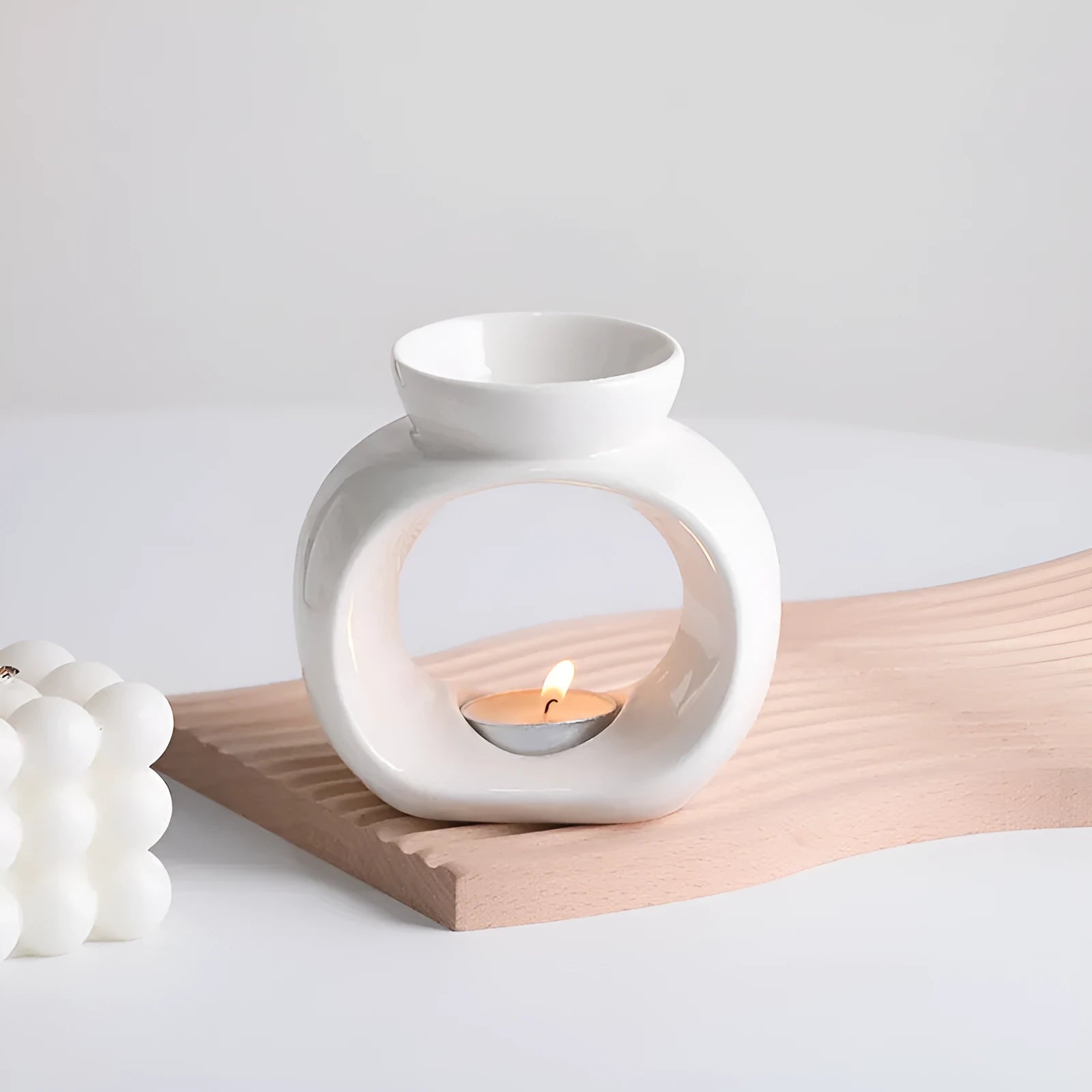 White Nordic style ceramic aromatherapy stove ornament on a wooden surface.