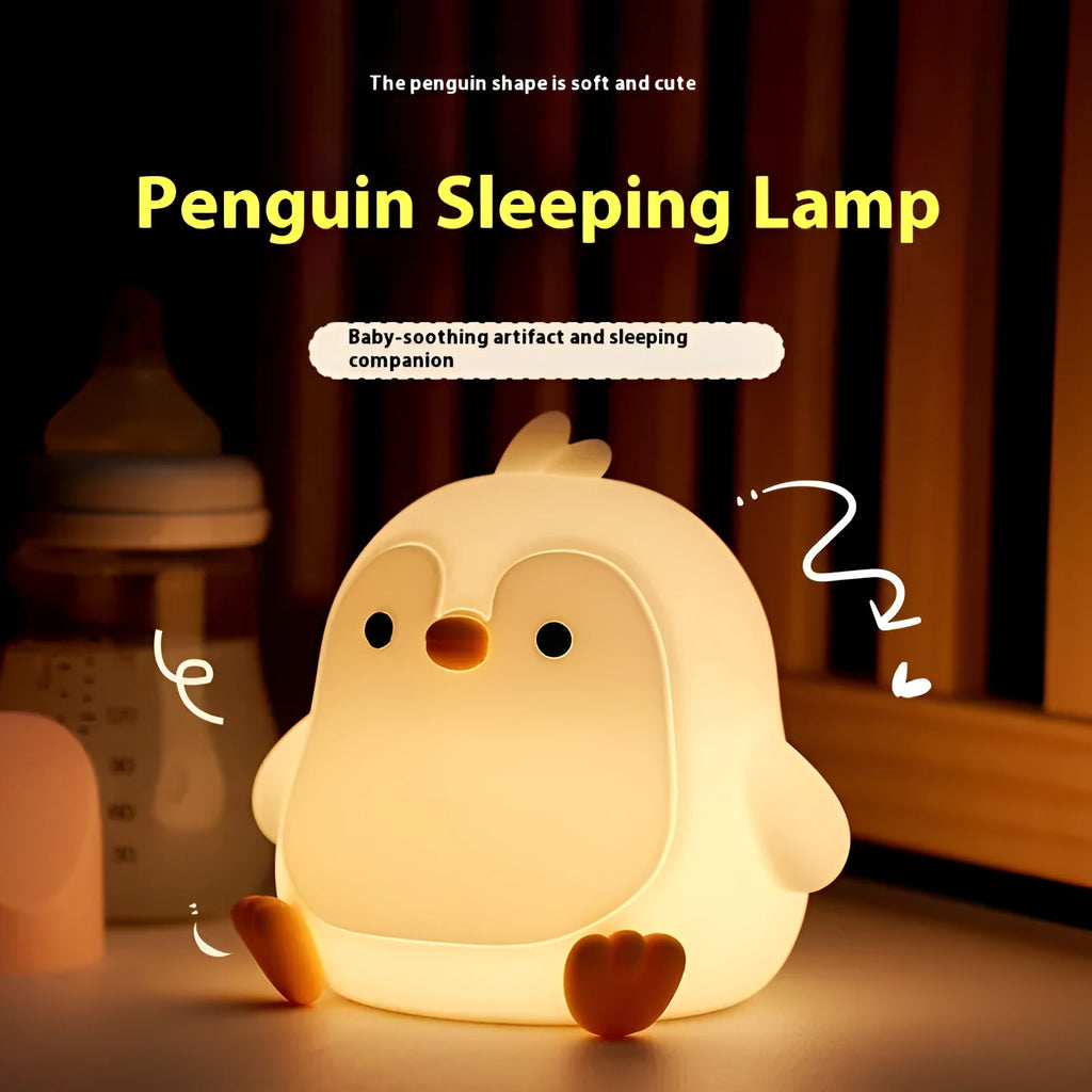 Baby penguin silicone small night lamp in black with warm light mode on bedside table