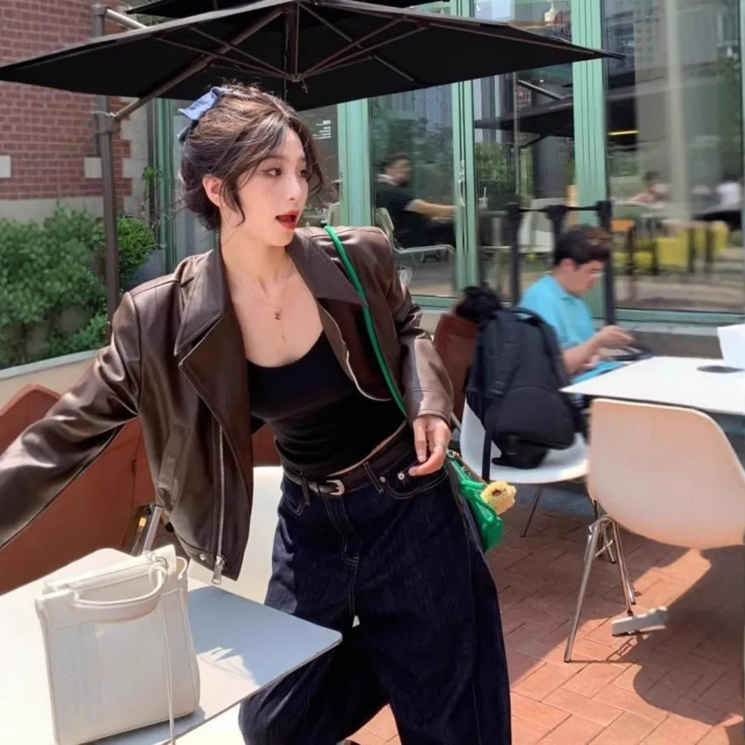 Brown women's retro slim-fit imitation leather jacket with pockets on a model.