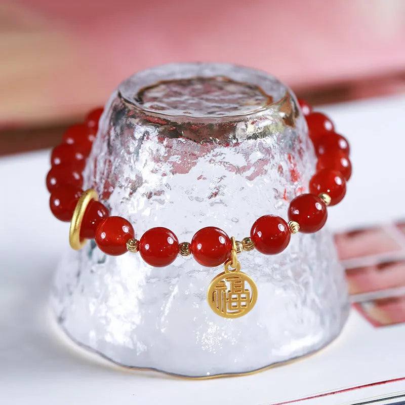 Natural red agate bracelet with woven bead design on a wrist.