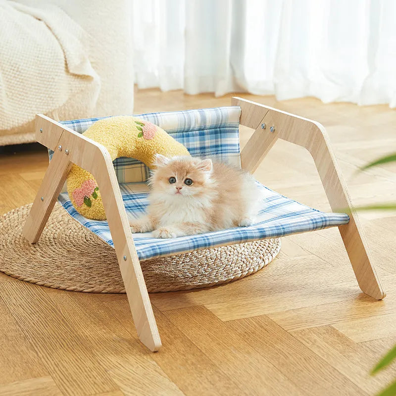 Wooden elevated cat bed with blue cloth hammock suspended inside frame