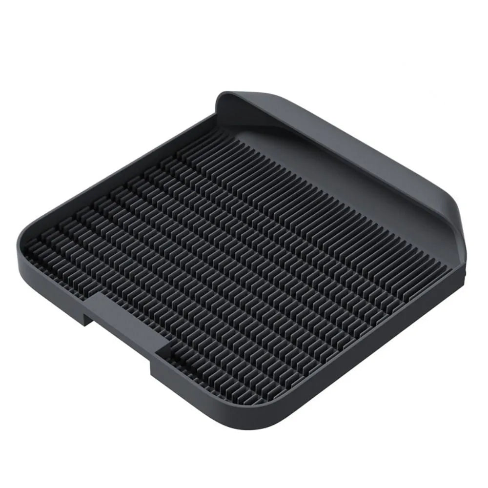 Large black cat litter pedal mat with slanted design next to a litter box.