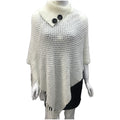 Sleeveless polka dot knit cloak in apricot colour, shown as a vest on a hanger.