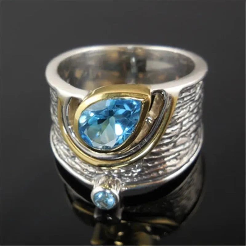 Blue zircon Chinese style women's ring with inlaid design showing drop shape silhouette